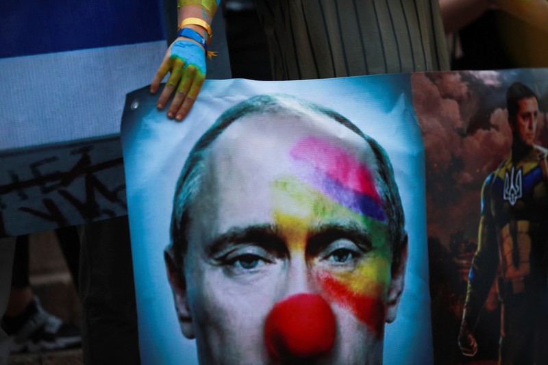 Seorang demonstran memegang poster protes warga Ukraina yang tinggal di Meksiko dan para demonstran untuk memperingati satu tahun invasi Rusia ke Ukraina, di monumen Malaikat Kemerdekaan di Mexico City, Meksiko 24 Februari 2023. (REUTERS/Henry Romero)
