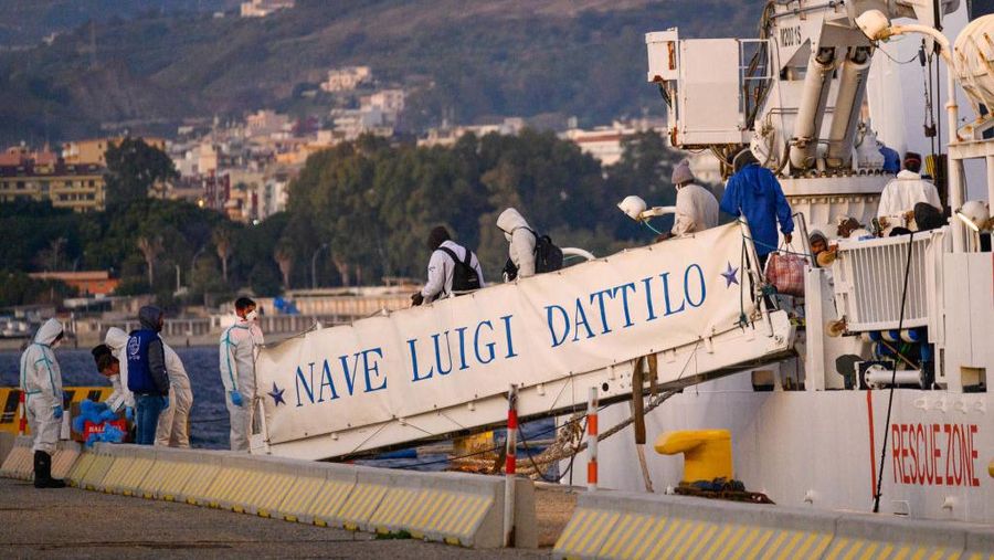 REGGIO CALABRIA, ITALY - 2023/02/20: Migrants seen walking on the footbridge. The Italian Coastguard rescue vessel