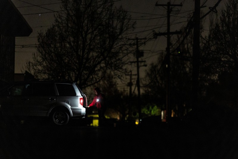Seorang pria berjalan di sepanjang jalan kosong dalam kegelapan, menyusul badai musim dingin yang besar yang meninggalkan rumah dan bisnis tanpa listrik, di Menlo Park, California A.S., 21 Februari 2023. (REUTERS/ Carlos Barria)