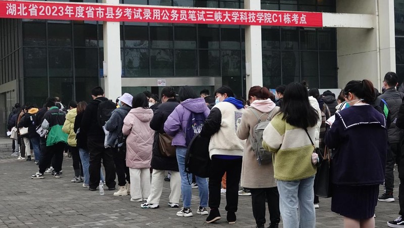 Peserta ujian China meninjau materi studi saat mereka menunggu untuk menghadiri ujian perekrutan pegawai negeri tahunan China untuk bersaing mendapatkan lowongan dengan otoritas pusat dan cabang mereka pada 25 Februari 2023 di Fuyang, Provinsi Anhui China. (VCG/VCG via Getty Images)