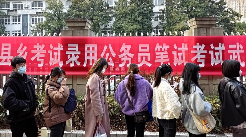 Peserta ujian China meninjau materi studi saat mereka menunggu untuk menghadiri ujian perekrutan pegawai negeri tahunan China untuk bersaing mendapatkan lowongan dengan otoritas pusat dan cabang mereka pada 25 Februari 2023 di Fuyang, Provinsi Anhui China. (VCG/VCG via Getty Images)