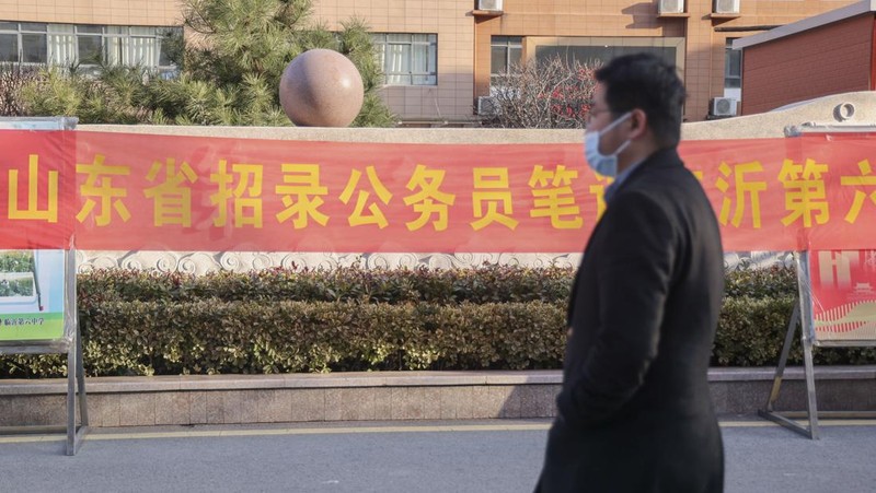 Peserta ujian China meninjau materi studi saat mereka menunggu untuk menghadiri ujian perekrutan pegawai negeri tahunan China untuk bersaing mendapatkan lowongan dengan otoritas pusat dan cabang mereka pada 25 Februari 2023 di Fuyang, Provinsi Anhui China. (VCG/VCG via Getty Images)