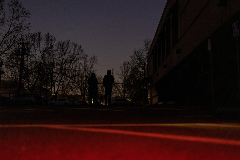 Seorang pria berjalan di sepanjang jalan kosong dalam kegelapan, menyusul badai musim dingin yang besar yang meninggalkan rumah dan bisnis tanpa listrik, di Menlo Park, California A.S., 21 Februari 2023. (REUTERS/ Carlos Barria)