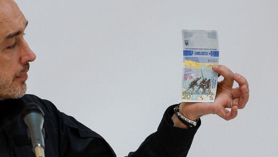 Gubernur Bank Nasional Ukraina Andriy Pyshnyi memegang uang kertas yang didedikasikan untuk peringatan satu tahun invasi Rusia di Ukraina, selama presentasi di Kyiv, Ukraina 23 Februari 2023. (REUTERS/Valentyn Ogirenko)