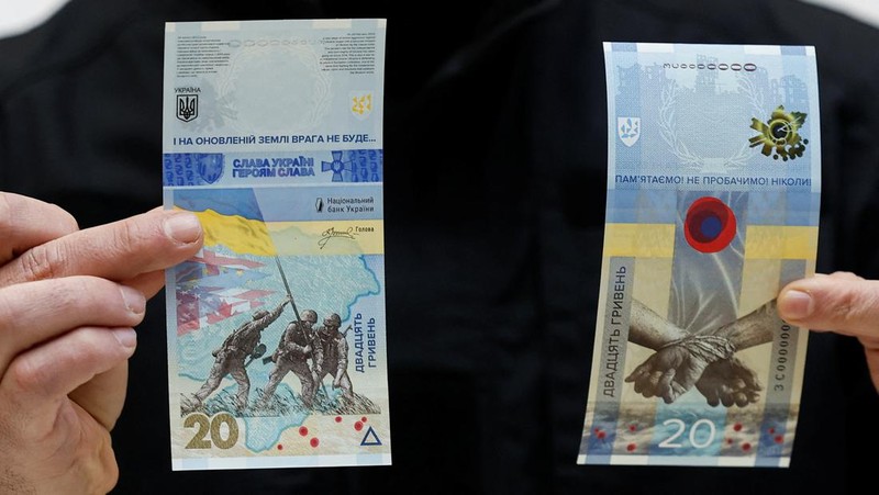 Gubernur Bank Nasional Ukraina Andriy Pyshnyi memegang uang kertas yang didedikasikan untuk peringatan satu tahun invasi Rusia di Ukraina, selama presentasi di Kyiv, Ukraina 23 Februari 2023. (REUTERS/Valentyn Ogirenko)