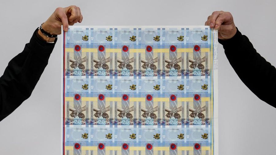 Gubernur Bank Nasional Ukraina Andriy Pyshnyi memegang uang kertas yang didedikasikan untuk peringatan satu tahun invasi Rusia di Ukraina, selama presentasi di Kyiv, Ukraina 23 Februari 2023. (REUTERS/Valentyn Ogirenko)