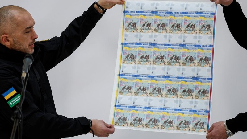 Gubernur Bank Nasional Ukraina Andriy Pyshnyi memegang uang kertas yang didedikasikan untuk peringatan satu tahun invasi Rusia di Ukraina, selama presentasi di Kyiv, Ukraina 23 Februari 2023. (REUTERS/Valentyn Ogirenko)