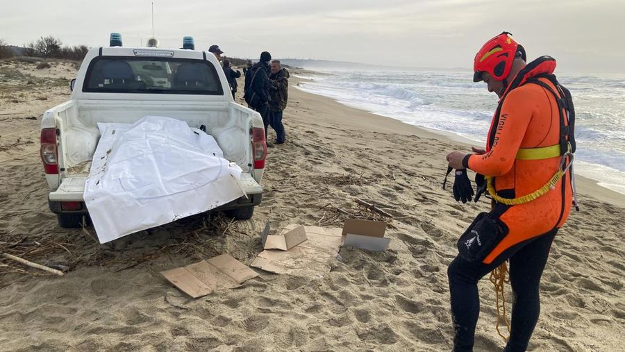 Italian Red Cross volunteers and coast guards recover a body after a migrant boat broke apart in rough seas, at a beach near Cutro, southern Italy, Sunday, Feb. 26, 2023. Rescue officials say an undetermined number of migrants have died and dozens have been rescued after their boat broke apart off southern Italy.(Antonino Durso/LaPresse via AP)