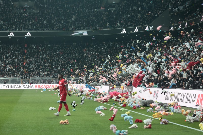 TURKEY-QUAKE/TOYS Fans throw toys on the pitch for children affected by earthquake during a Turkish Super League match between Besiktas and Antalyaspor at Vodafone Park in Istanbul, Turkey February 26, 2023. REUTERS/Stringer NO RESALES. NO ARCHIVES.