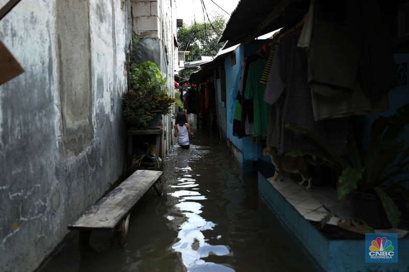 Warga beraktifitas saat banjir setinggi 60 cm menggenangi kawasan Pesing Koneng, Jakarta, Senin (27/2/2023). (CNBC Indonesia/Tri Susilo)