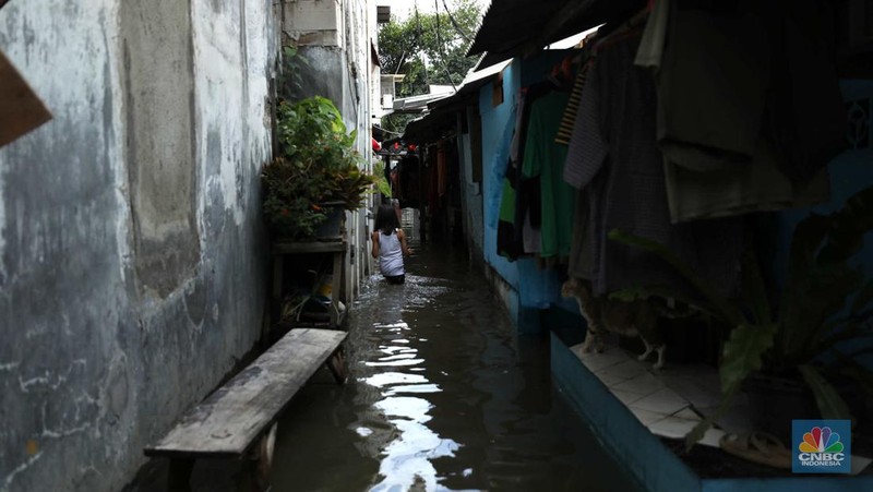 Warga beraktifitas saat banjir setinggi 60 cm menggenangi kawasan Pesing Koneng, Jakarta, Senin (27/2/2023). (CNBC Indonesia/Tri Susilo)