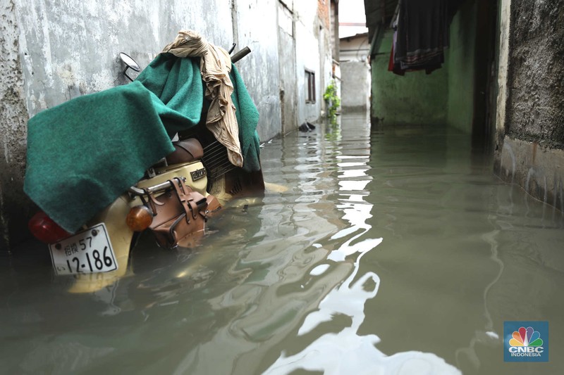 Warga beraktifitas saat banjir setinggi 60 cm menggenangi kawasan Pesing Koneng, Jakarta, Senin (27/2/2023). (CNBC Indonesia/Tri Susilo)