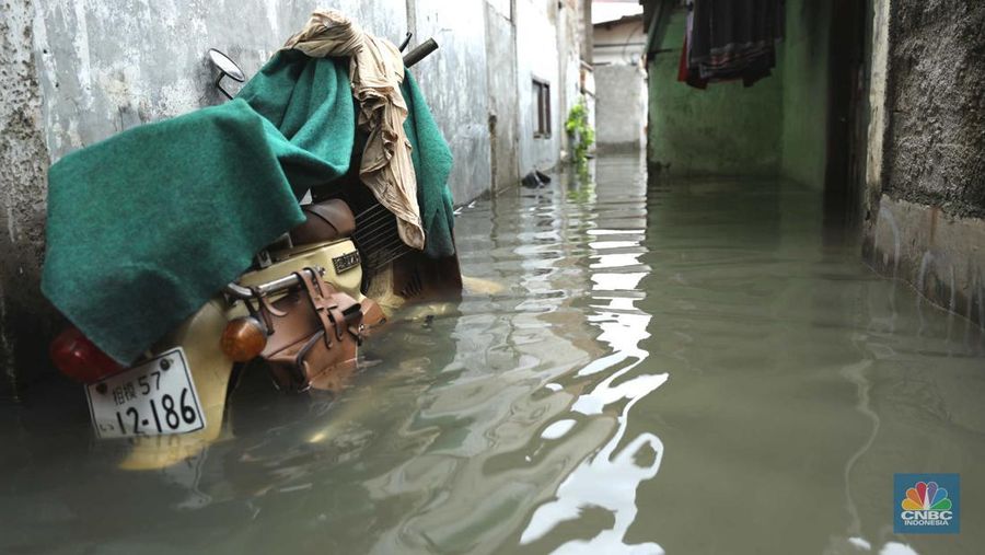 Warga beraktifitas saat banjir setinggi 60 cm menggenangi kawasan Pesing Koneng, Jakarta, Senin (27/2/2023). (CNBC Indonesia/Tri Susilo)