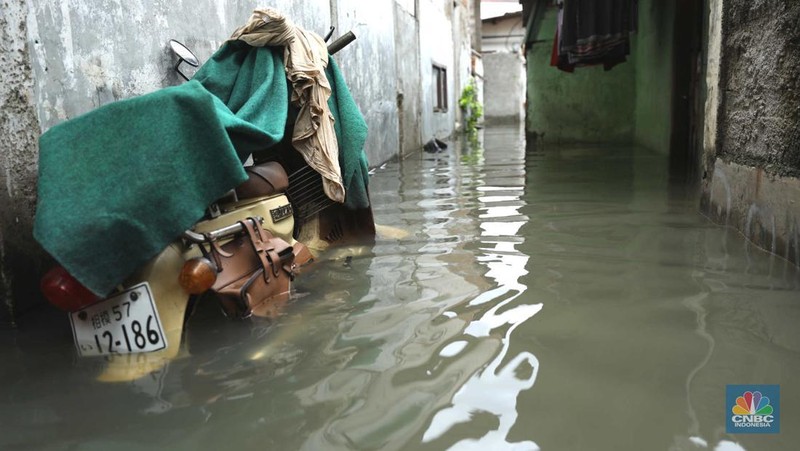 Warga beraktifitas saat banjir setinggi 60 cm menggenangi kawasan Pesing Koneng, Jakarta, Senin (27/2/2023). (CNBC Indonesia/Tri Susilo)