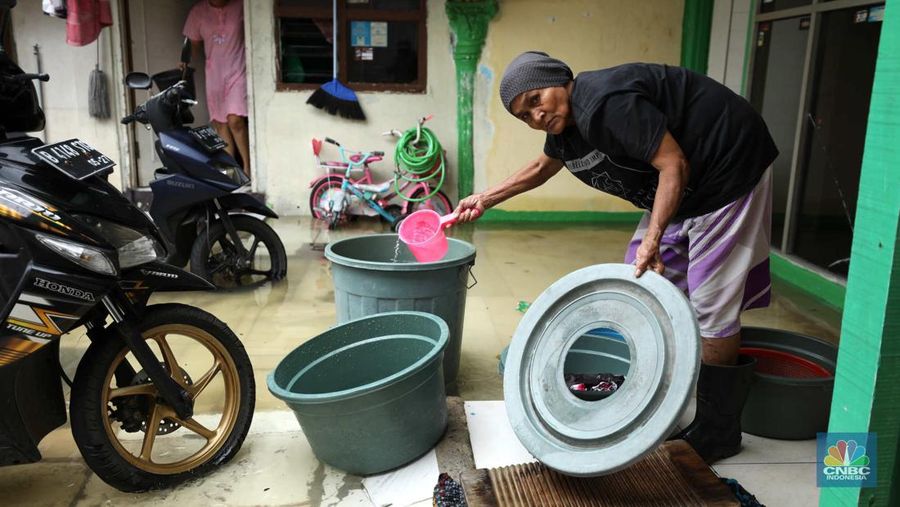 Warga beraktifitas saat banjir setinggi 60 cm menggenangi kawasan Pesing Koneng, Jakarta, Senin (27/2/2023). (CNBC Indonesia/Tri Susilo)