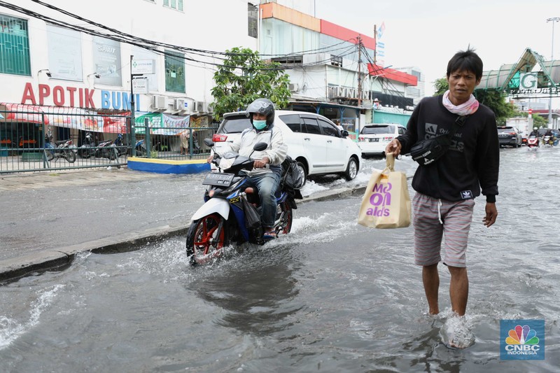 Warga menyelamatkan hewan peliharaannya untuk melewati genangan banjir di Kawasan Green Garden, Jakarta, Senin (27/2/2023). Warga menyelamatkan hewan peliharaannya untuk melewati genangan banjir di Kawasan Green Garden, Jakarta, Senin (27/2/2023). (CNBC Indonesia/Tri Susilo)