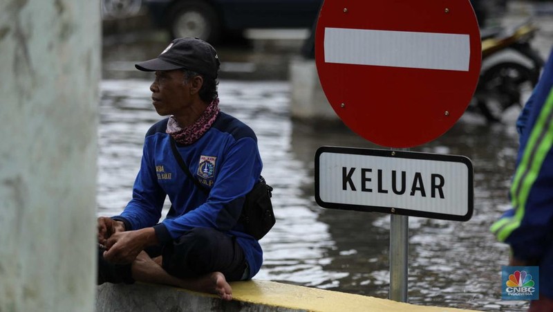 Warga menyelamatkan hewan peliharaannya untuk melewati genangan banjir di Kawasan Green Garden, Jakarta, Senin (27/2/2023). (CNBC Indonesia/Tri Susilo)