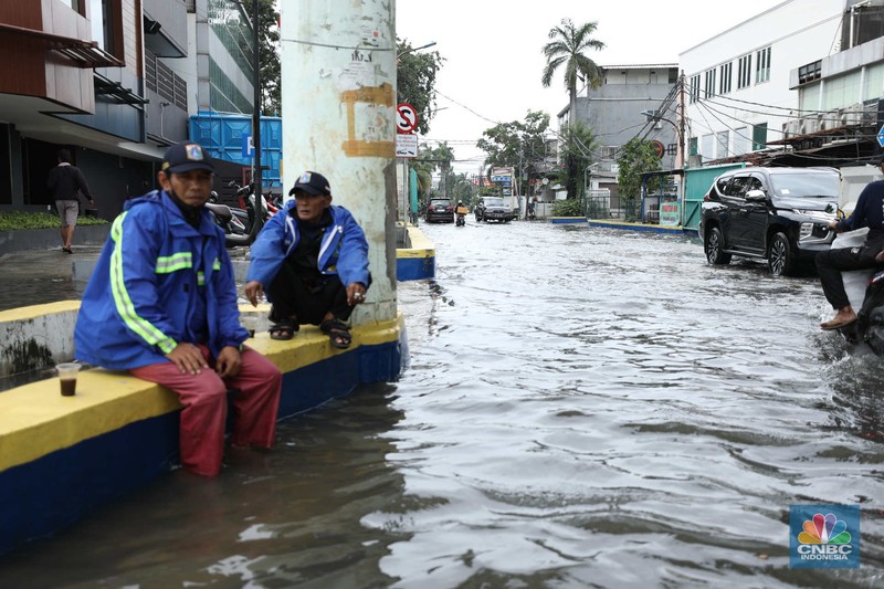 Warga menyelamatkan hewan peliharaannya untuk melewati genangan banjir di Kawasan Green Garden, Jakarta, Senin (27/2/2023). Warga menyelamatkan hewan peliharaannya untuk melewati genangan banjir di Kawasan Green Garden, Jakarta, Senin (27/2/2023). (CNBC Indonesia/Tri Susilo)