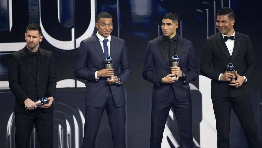 Lionel Messi, left, Kylian Mbappe, second left, Achraf Hakimi, second right and Casemiro pose with trophies Men's World 11 during the ceremony of the Best FIFA Football Awards in Paris, France, Monday, Feb. 27, 2023. (AP Photo/Michel Euler)