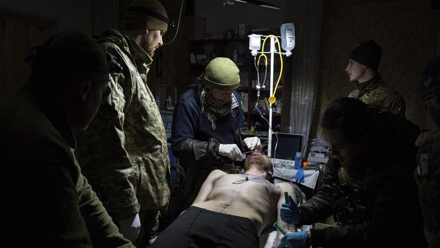 Ukrainian military medics treat their wounded comrade at a field hospital near Bakhmut, Ukraine, Wednesday, March 1, 2023. (AP Photo/Evgeniy Maloletka)