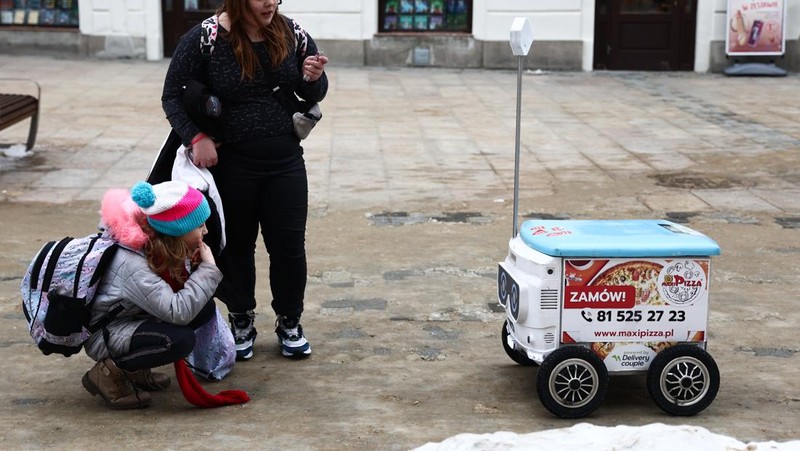 Robot pengantar makanan bernama Kasia terlihat dipresentasikan di jalan di Lublin, Polandia pada 10 Februari 2023. Perusahaan startup Delivery Couple memproduksi dan mengoperasikan robot semi-otonom yang mengantarkan makanan di delapan kota di Polandia saat ini. (Jakub Porzycki/Anadolu Agency via Getty Images)