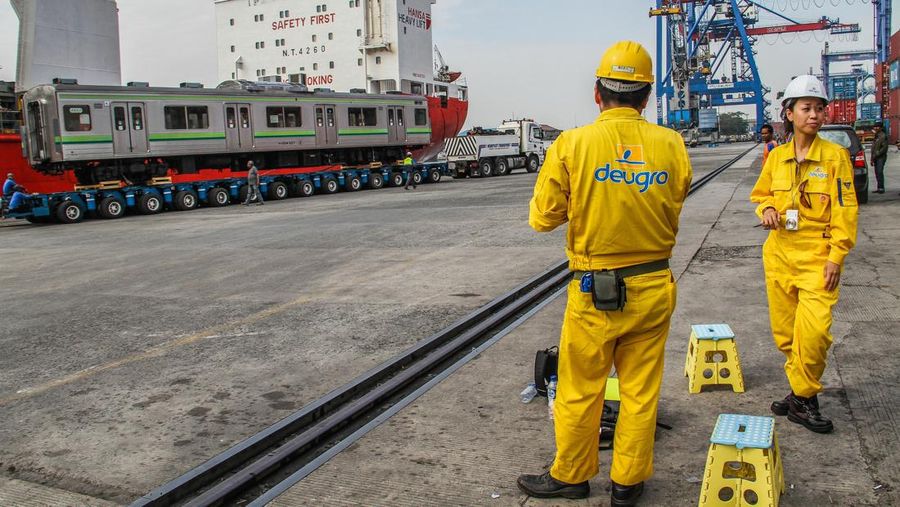 TANJUNG PRIOK, JAKARTA, INDONESIA - 2015/05/05: Japanese engineers are monitoring the railroad cars that are being lowered from a ship onto truck carriage. PT KAI Commuter Jabodetabek (KJC) bring 32 units of KRL purchased a used 205 series from Japan. The train is the first stage of the delivery program for the procurement of 176 units of KRL 2014. (Photo by Garry Andrew Lotulung/Pacific Press/LightRocket via Getty Images)
