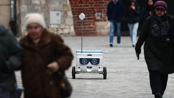 Robot pengantar makanan bernama Mateusz mengendarai jalan di Lublin, Polandia pada 10 Februari 2023. Perusahaan startup Delivery Couple memproduksi dan mengoperasikan robot semi-otonom yang mengantarkan makanan di delapan kota Polandia saat ini. (Jakub Porzycki/Anadolu Agency via Getty Images)