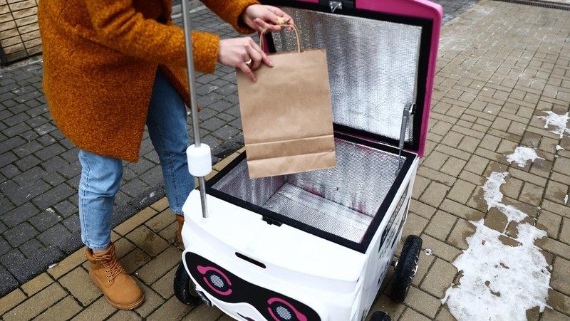 Robot pengantar makanan bernama Kasia terlihat dipresentasikan di jalan di Lublin, Polandia pada 10 Februari 2023. Perusahaan startup Delivery Couple memproduksi dan mengoperasikan robot semi-otonom yang mengantarkan makanan di delapan kota di Polandia saat ini. (Jakub Porzycki/Anadolu Agency via Getty Images)