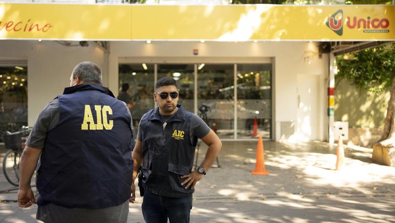 A police officer stands guard outside a supermarket that belongs to the family of Antonela Roccuzzo, wife of Argentine soccer star Lionel Messi, after after two people on motorcycles attacked it and left a threatening message for Messi and the city mayor, Pablo Javkin, according to local media, in Rosario, Argentina March 2, 2023. REUTERS/Luciano Bisbal NO RESALES. NO ARCHIVES