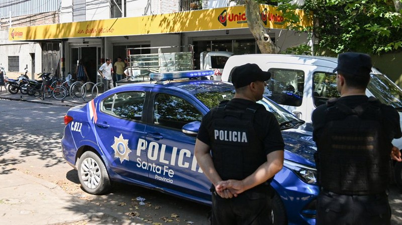 A police officer stands guard outside a supermarket that belongs to the family of Antonela Roccuzzo, wife of Argentine soccer star Lionel Messi, after after two people on motorcycles attacked it and left a threatening message for Messi and the city mayor, Pablo Javkin, according to local media, in Rosario, Argentina March 2, 2023. REUTERS/Luciano Bisbal NO RESALES. NO ARCHIVES