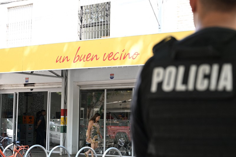 ARGENTINA-VIOLENCE/MESSI A police officer stands guard outside a supermarket that belongs to the family of Antonela Roccuzzo, wife of Argentine soccer star Lionel Messi, after after two people on motorcycles attacked it and left a threatening message for Messi and the city mayor, Pablo Javkin, according to local media, in Rosario, Argentina March 2, 2023. REUTERS/Luciano Bisbal NO RESALES. NO ARCHIVES