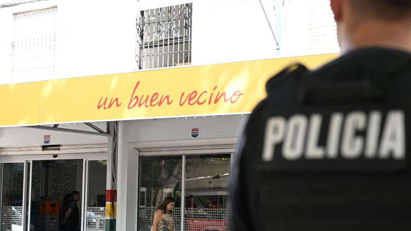 A police officer stands guard outside a supermarket that belongs to the family of Antonela Roccuzzo, wife of Argentine soccer star Lionel Messi, after after two people on motorcycles attacked it and left a threatening message for Messi and the city mayor, Pablo Javkin, according to local media, in Rosario, Argentina March 2, 2023. REUTERS/Luciano Bisbal NO RESALES. NO ARCHIVES