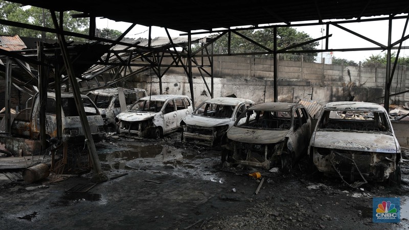 Warga melewati kendaraan yang hangus terbakar di lokasi terdampak kebakaran Depo Pertamina Plumpang di Kampung Tanah Merah Bawah, Koja, Jakarta Utara, Sabtu (4/3/2023). (CNBC Indonesia/Tri Susilo)