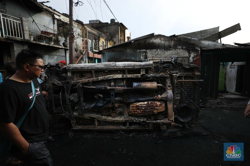 Warga melewati kendaraan yang hangus terbakar di lokasi terdampak kebakaran Depo Pertamina Plumpang di Kampung Tanah Merah Bawah, Koja, Jakarta Utara, Sabtu (4/3/2023). (CNBC Indonesia/Tri Susilo) Warga melewati kendaraan yang hangus terbakar di lokasi terdampak kebakaran Depo Pertamina Plumpang di Kampung Tanah Merah Bawah, Koja, Jakarta Utara, Sabtu (4/3/2023). (CNBC Indonesia/Tri Susilo)