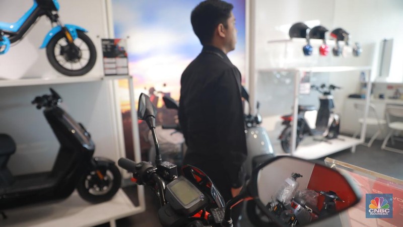 Salah satu pegawai mekanik motor listrik melihat motor listrik di salah satu showroom di kawasan Arteri, Senin (11/10/2022). (CNBC Indonesia/ Muhammad Sabki)