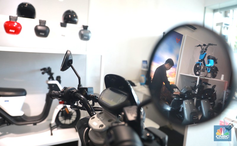Salah satu pegawai mekanik motor listrik melihat motor listrik di salah satu showroom di kawasan Arteri, Senin (11/10/2022). (CNBC Indonesia/ Muhammad Sabki)