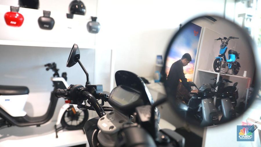 Salah satu pegawai mekanik motor listrik melihat motor listrik di salah satu showroom di kawasan Arteri, Senin (11/10/2022). (CNBC Indonesia/ Muhammad Sabki)