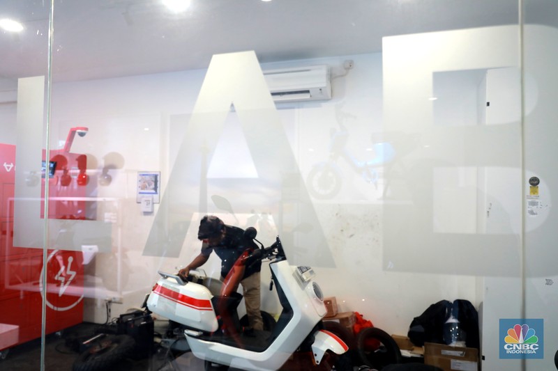 Salah satu pegawai mekanik motor listrik melihat motor listrik di salah satu showroom di kawasan Arteri, Senin (11/10/2022). Salah satu pegawai mekanik motor listrik melihat motor listrik di salah satu showroom di kawasan Arteri, Senin (11/10/2022). (CNBC Indonesia/ Muhammad Sabki)