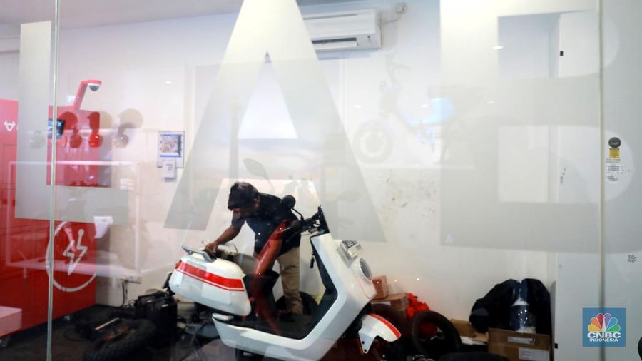 Salah satu pegawai mekanik motor listrik melihat motor listrik di salah satu showroom di kawasan Arteri, Senin (11/10/2022). (CNBC Indonesia/ Muhammad Sabki)