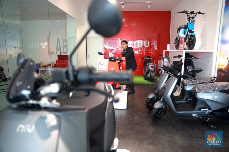 Salah satu pegawai mekanik motor listrik melihat motor listrik di salah satu showroom di kawasan Arteri, Senin (11/10/2022). (CNBC Indonesia/ Muhammad Sabki)