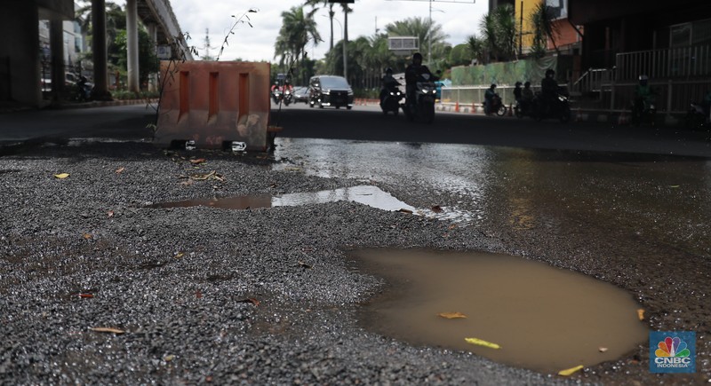 Sejumlah kendaraan melintas di kawasan jalan berlubang di Jalan Metro Pondok Indah, Jakarta, Senin, 6/3. Ruas jalan tersbut terlihat terdapat jalan yang berlubang dan basah sehingga dapat membahayakan pengguna jalan. (CNBC Indonesia/ Muhammad Sabki)