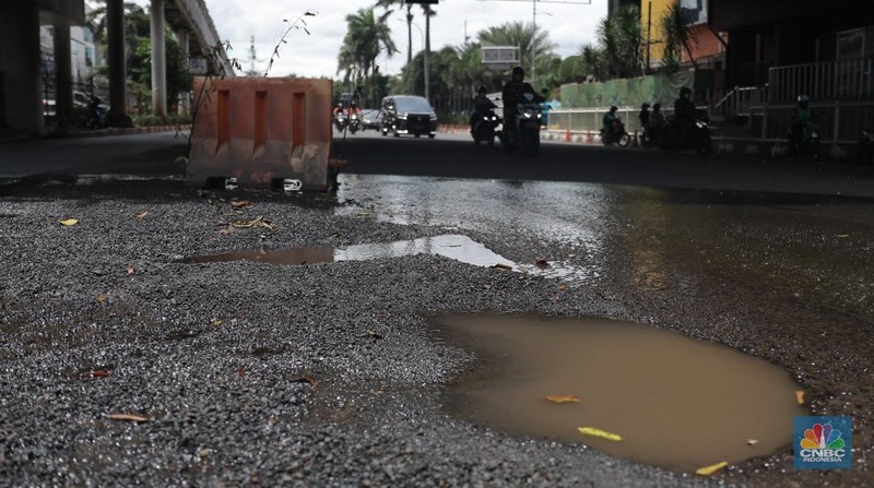Sejumlah kendaraan melintas di kawasan jalan berlubang di Jalan Metro Pondok Indah, Jakarta, Senin, 6/3. Ruas jalan tersbut terlihat terdapat jalan yang berlubang dan basah sehingga dapat membahayakan pengguna jalan. (CNBC Indonesia/ Muhammad Sabki)