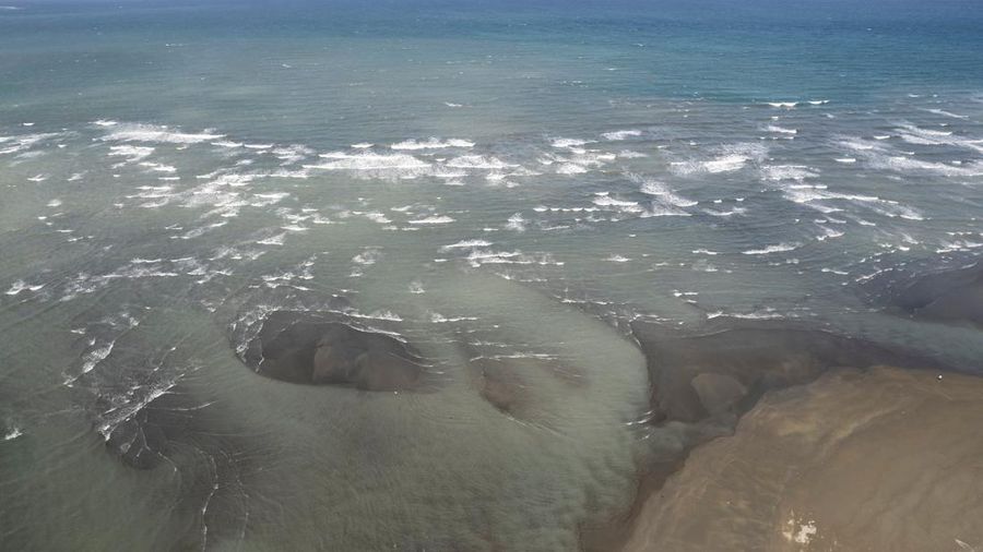 Relawan menggunakan alat pelindung diri (APD) sedang membersihkan tumpahan minyak dari kapal tanker bahan bakar MT Princess Empress yang tenggelam, di pantai Pola, di provinsi Oriental Mindoro, Filipina, (7/3/2023). (REUTERS/ELOISA LOPEZ)