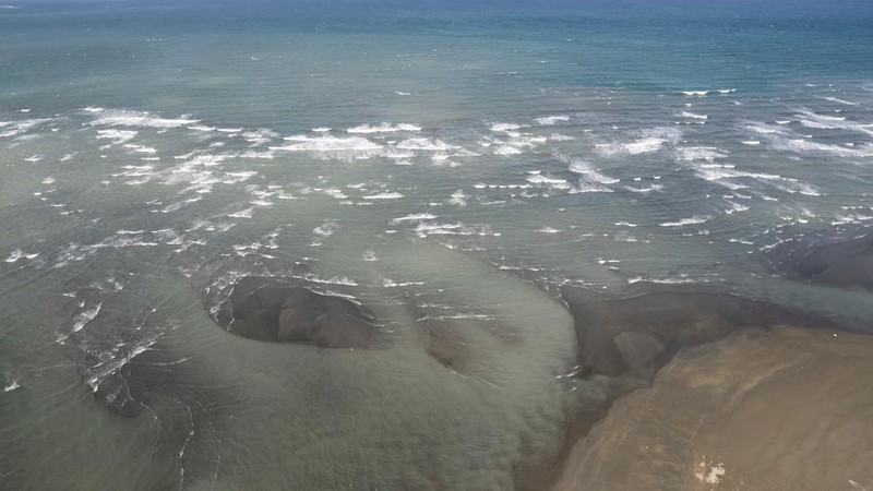 Relawan menggunakan alat pelindung diri (APD) sedang membersihkan tumpahan minyak dari kapal tanker bahan bakar MT Princess Empress yang tenggelam, di pantai Pola, di provinsi Oriental Mindoro, Filipina, (7/3/2023). (REUTERS/ELOISA LOPEZ)