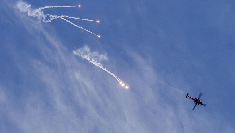 Helikopter serang AH-64 Apache Longbow Israel melepaskan suar saat terbang selama serangan tentara Israel di kamp Jenin untuk pengungsi Palestina di Tepi Barat yang diduduki pada 7 Maret 2023. - Pasukan Israel membunuh enam warga Palestina di Jenin pada 7 Maret, termasuk tersangka militan yang dituduh membunuh dua warga Israel. Kementerian kesehatan Palestina mengatakan enam pria tewas, satu berusia 49 tahun dan sisanya berusia 20-an, dalam bentrokan yang menurut tentara termasuk tentara yang meluncurkan roket di tengah tembakan ganas. (JAAFAR ASHTIYEH/AFP via Getty Images)
