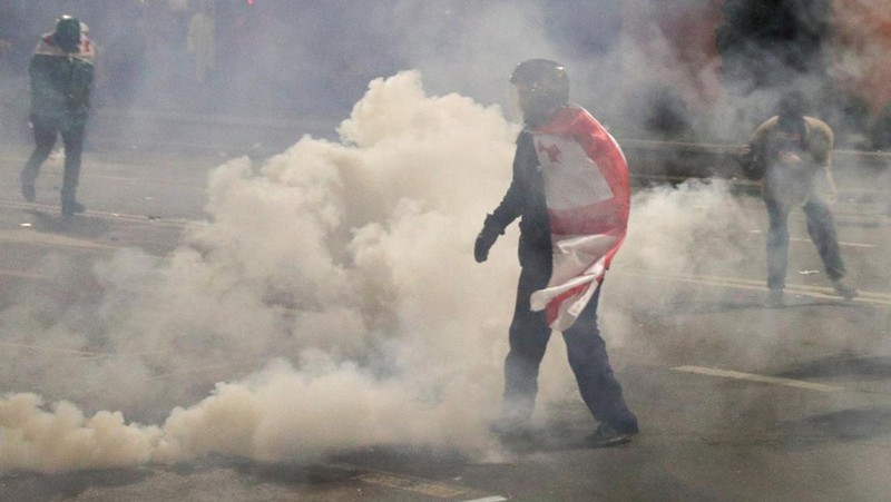 Demonstrasn di depan parlemen Yunani melempar molotov lalu dibalas dengan tembakkan gas air mata oleh polisi. (REUTERS/IRAKLI GEDENIDZE)