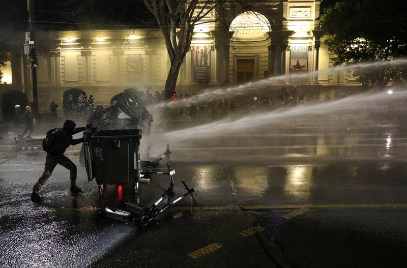 Demonstrasn di depan parlemen Yunani melempar molotov lalu dibalas dengan tembakkan gas air mata oleh polisi. (REUTERS/IRAKLI GEDENIDZE)