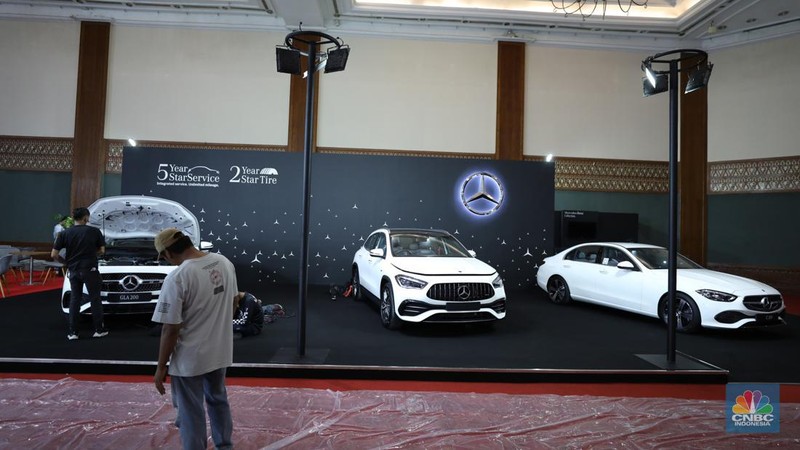 Pekerja menyelesaikan dekorasi booth pameran Gabungan Industri Kendaraan Bermotor Indonesia (Gaikindo) Auto Week Jakarta di Jakarta Convention Center (JCC), Kamis (9/3/2023). (CNBC Indonesia/Tri Susilo)