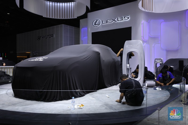 Pekerja menyelesaikan dekorasi booth pameran Gabungan Industri Kendaraan Bermotor Indonesia (Gaikindo) Auto Week Jakarta di Jakarta Convention Center (JCC), Kamis (9/3/2023). (CNBC Indonesia/Tri Susilo)