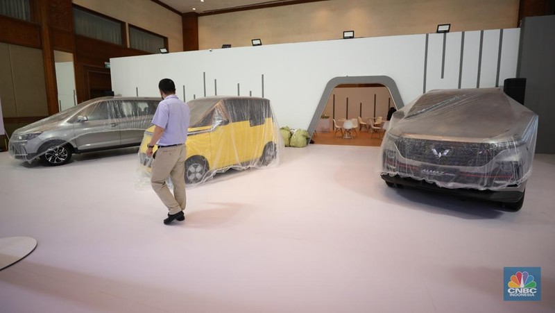Pekerja menyelesaikan dekorasi booth pameran Gabungan Industri Kendaraan Bermotor Indonesia (Gaikindo) Auto Week Jakarta di Jakarta Convention Center (JCC), Kamis (9/3/2023). (CNBC Indonesia/Tri Susilo)